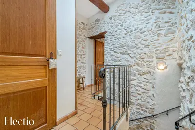 a hallway with a wooden door and a stone wall at Mas La Miellerie - Charme Authentique et Nature in Simiane-la-Rotonde