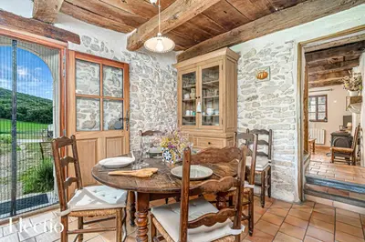 a dining room with a table and a stone wall at Mas La Miellerie - Charme Authentique et Nature in Simiane-la-Rotonde