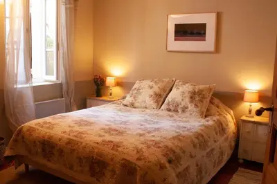 a bedroom with a bed with two lamps and a window at 40 Rue du Ventoux in Bédoin