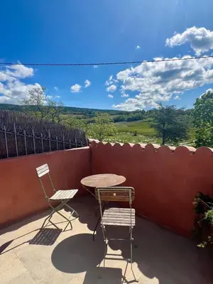 a table and two chairs on a patio with a view at 40 Rue du Ventoux in Bédoin