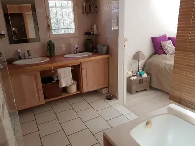 a bathroom with two sinks and a bed and a tub at Détente champêtre in Lambesc