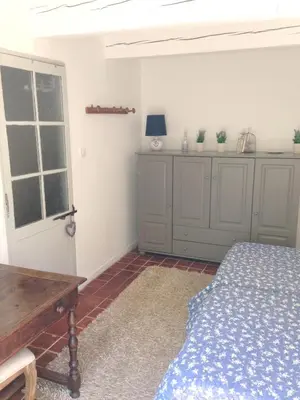 a bedroom with a bed and a table and a window at Maison charmante à Modène avec piscine privée in Modène
