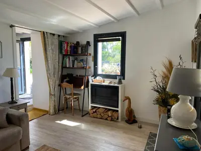 a living room with a television and a table at Maison charmante à Modène avec piscine privée in Modène
