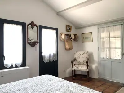 a bedroom with a bed and a chair and a mirror at Maison charmante à Modène avec piscine privée in Modène