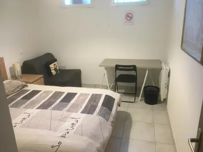 a bedroom with a bed and a desk and a chair at Gites Velaux Ecureuil et Pinède in Velaux