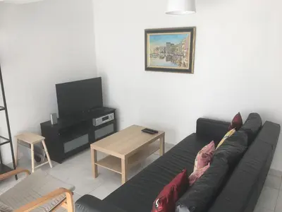 a living room with a black couch and a table at Gites Velaux Ecureuil et Pinède in Velaux