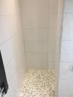 a bathroom with a shower with a tiled floor at Gites Velaux Ecureuil et Pinède in Velaux