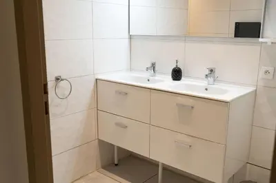a white bathroom with a sink and a mirror at Gites Velaux Ecureuil et Pinède in Velaux
