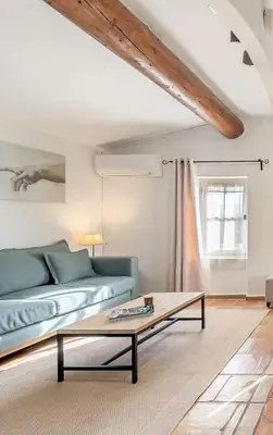 a living room with a blue couch and a coffee table at Mas Oréa Sous la glycine in Gordes