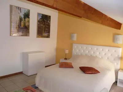 a bedroom with a white bed with two pillows on it at Miel de Lavande in LʼIsle-sur-la-Sorgue