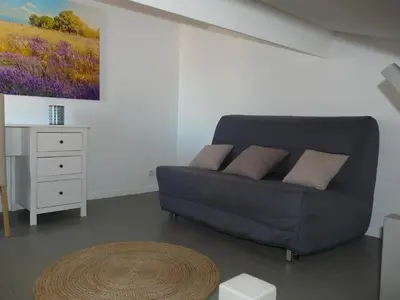 a living room with a couch and a table at Miel de Lavande in LʼIsle-sur-la-Sorgue