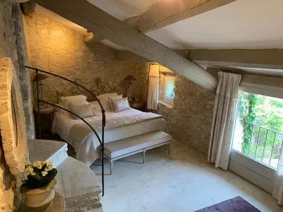 a bedroom with a bed in a room with a window at Villa Grenache, La Bastide de Marie, Villa avec services in Ménerbes