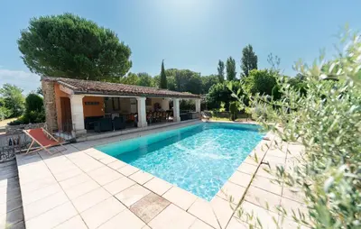 a swimming pool with a patio and a house at Bastide Les Basses Royères in Robion en Luberon