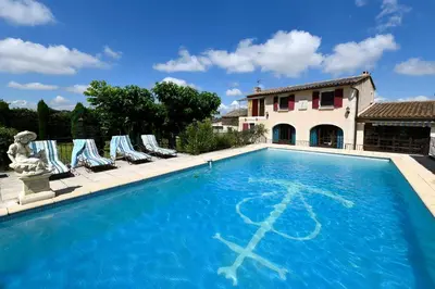 a swimming pool with lounge chairs and a house at Bastide Les Basses Royères in Robion en Luberon