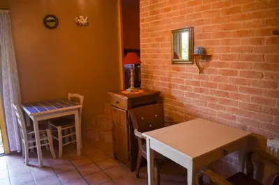 a kitchen with a table and a small table and a table and chair at Bastide Les Basses Royères in Robion en Luberon