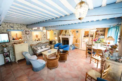 a living room with a couch and a table and chairs at Bastide Les Basses Royères in Robion en Luberon