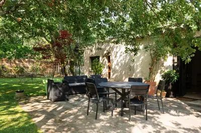 a table and chairs under a tree in a yard at Maison d’Etienne in Lacoste