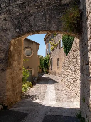 an alley through an arch in a stone wall at Location Bonnieux Provence in Bonnieux