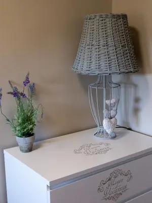 a lamp on top of a dresser with a plant at Location Bonnieux Provence in Bonnieux