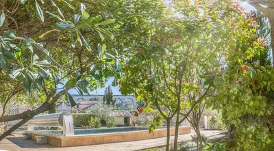a park with a bench in the middle of trees at A jewel by the river! in Fontaine-de-Vaucluse
