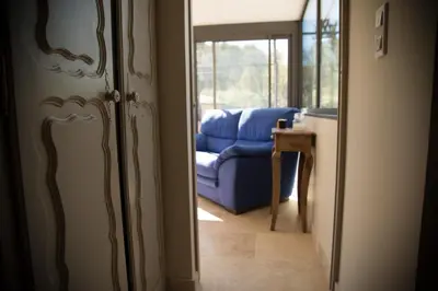 a door to a living room with a blue couch at A jewel by the river! in Fontaine-de-Vaucluse