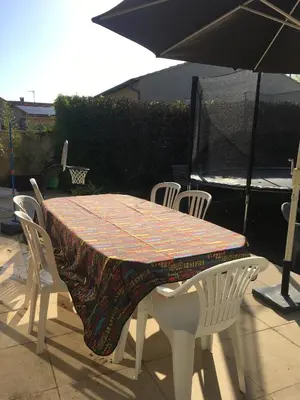 a table with chairs and an umbrella on a patio at Maison de village in Velleron