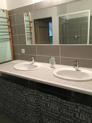 a public bathroom with two sinks and a mirror at Maison de village in Velleron