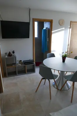a living room with a table and chairs and a tv at Les Hauts De Reillanne in Reillanne