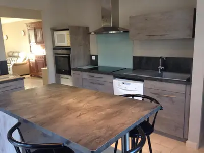 a kitchen with a wooden table and chairs at La roseraie Bonnieux in Bonnieux