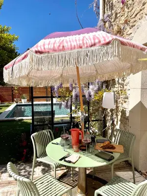a table and chairs under an umbrella on a patio at Maison Florence Ivakno in Coudoux