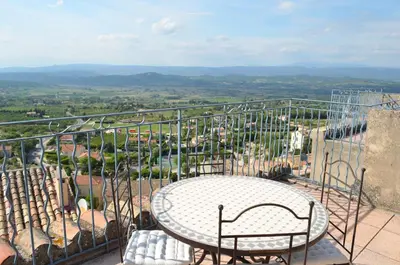 a table and chairs on a balcony with a view at Logis Hôtel Panoramique César in Bonnieux