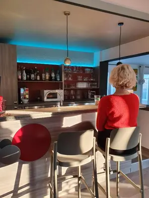 a woman sitting at a bar in a kitchen at Hôtel Saint Louis in Le Thor