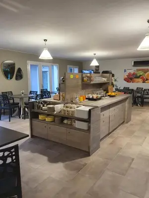 a kitchen with a counter with food on it at Hôtel Saint Louis in Le Thor