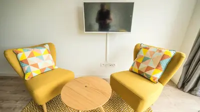 a living room with two chairs and a table at Les Terrasses de Cascavelle in Blauvac
