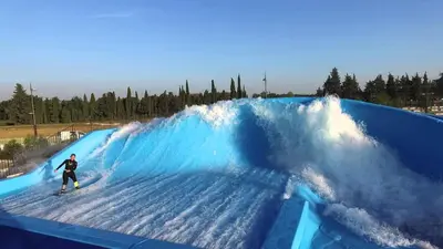 a man riding a wave on a surfboard in a wave tunnel at Entre Vignes et Collines in Méthamis
