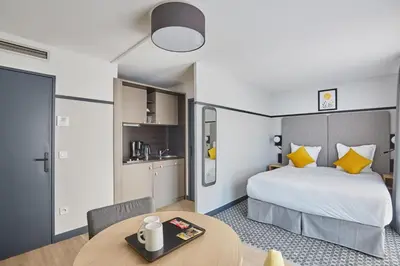 a hotel room with a bed and a table at Appart'hôtel Odalys City - Aix en Provence Centre Rotonde in Aix-en-Provence