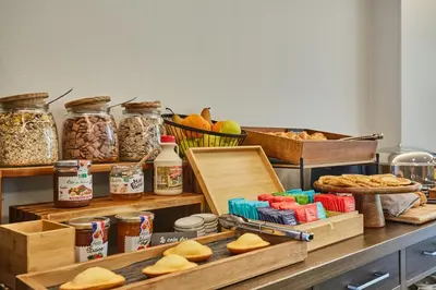 a table with bread and other food items on it at Appart'hôtel Odalys City - Aix en Provence Centre Rotonde in Aix-en-Provence