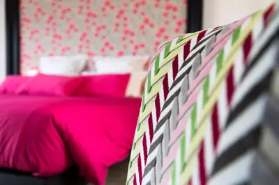 a bedroom with a pink bed with pink pillows at Chut ! c'est ici in Venelles