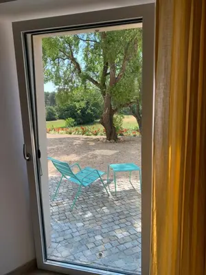 a sliding glass door with a chair and a table outside at Chut ! c'est ici in Venelles