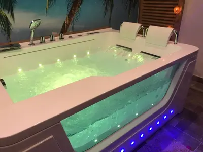 a jacuzzi tub in a house with two chairs in it at Le Mas Romantique avec Jacuzzi et Sauna privé in Sénas