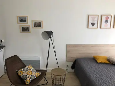 a bedroom with a bed and a chair and a lamp at Aix Homes in Aix-en-Provence