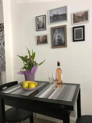 a table with a bottle of wine and a plate of fruit at Aix Homes in Aix-en-Provence