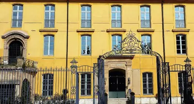a yellow building with a gate and a door at Aix Homes in Aix-en-Provence