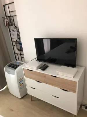 a white entertainment center with a television and a printer at Aix Homes in Aix-en-Provence