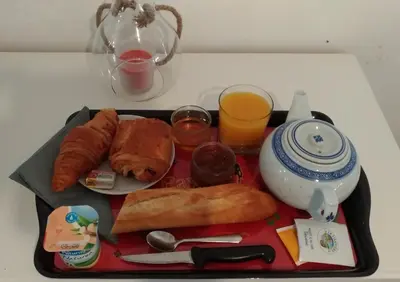 a tray of breakfast food with bread and orange juice at L'ilot de Carpentras in Carpentras