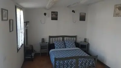 a bedroom with a bed with a blue comforter at L'ilot de Carpentras in Carpentras
