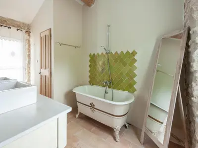 a bathroom with a tub and a sink and a mirror at Villa in Saignon with Pool and Scenic Views in Ménerbes