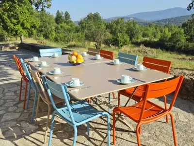 a wooden table with chairs and a tableasteryasteryasteryasteryasteryasteryasteryastery at Villa in Saignon with Pool and Scenic Views in Ménerbes