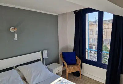 a bedroom with a bed and a window and a chair at Le palais, hôtel - restaurant in Apt