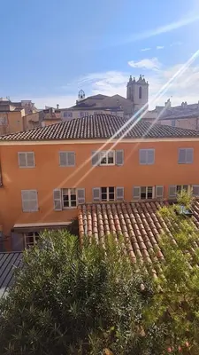 an orange building with a roof and some bushes at Sunny Apartment with Nice View in History City Center in Aix-en-Provence